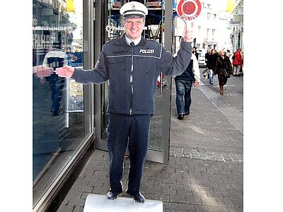 Freundlicher Polizist als lebensgroßer Aufsteller